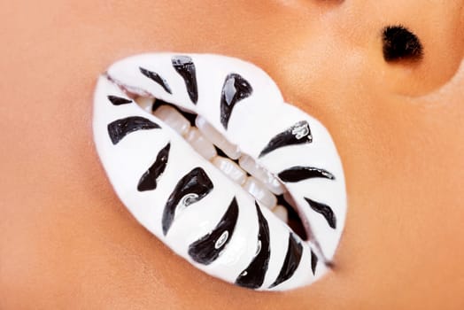 female mouth closeup. white lipstick with black stripes. skin color background.