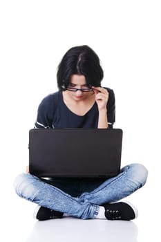 attractive young woman sitting in front of a laptop. isolated on white.