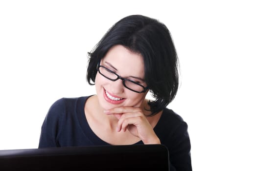attractive young woman sitting in front of a laptop. isolated on white.