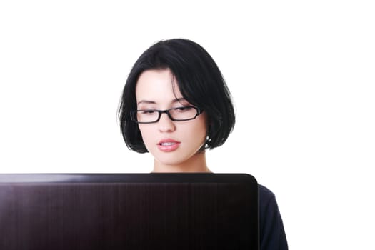 attractive young woman sitting in front of a laptop. isolated on white.