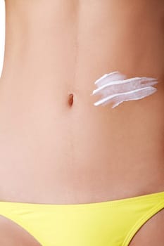 slim sexy female's belly with lotion body. closeup. isolated on white.