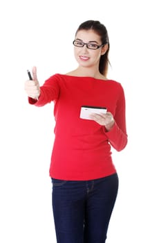 attractive young woman skowing ok,standing with pen and paper. isolated on white.