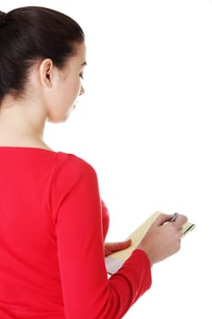 happy casual woman writing on a piece of paper. back view. isolated on white.
