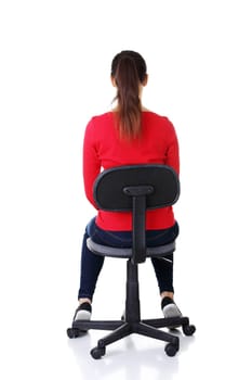 happy casual woman sitting on a chair. back view. isolated on white.