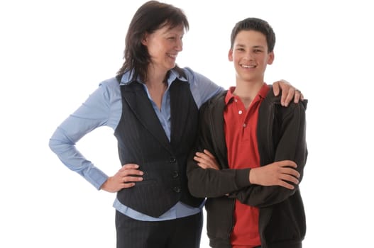 Mother and son stand next to each other,she embraces the boy in front of a white background.