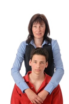 Mother and son stand next to each other,she embraces the boy in front of a white background.