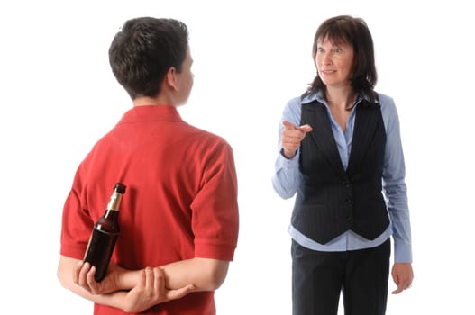Mother catches her teenage son with a bottle of beer and scolds him against a white background.
