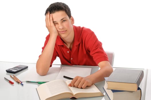 Boy sits exhausted and frustrated about homework at desk in front of a white background