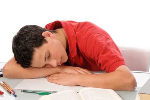 Boy sits exhausted and frustrated about homework at desk in front of a white background