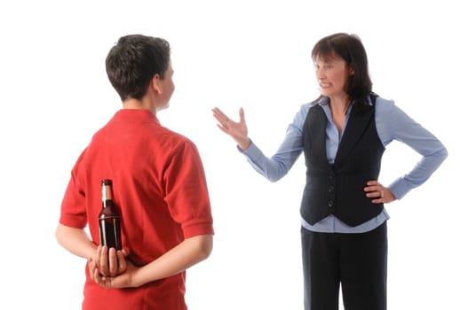 Mother catches her teenage son with a bottle of beer and scolds him against a white background.