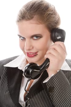Young woman in grey business suit and high heels making calls with landline telephone against a white background