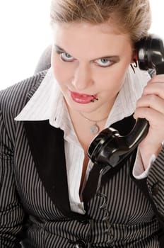 Young woman in grey business suit and high heels making calls with landline telephone against a white background