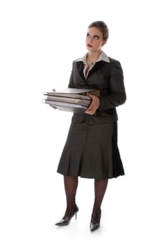 Young woman in a gray business suit and high heels carries a stack of files against a white background