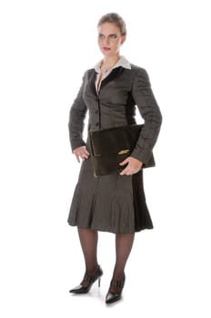 Young woman in grey business suit and high heels stands with leather folder against a white background