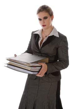 Young woman in a gray business suit and high heels carries a stack of files against a white background
