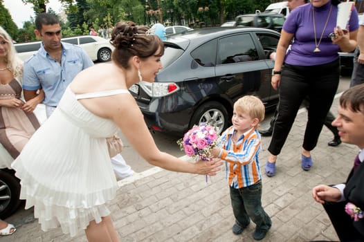 Moscow, Russia - July 10 2010. Traditional Russian weddind. The little boy congratulates on wedding and gives flowers to the bride