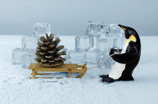 Penguin pulling sled with a giant fir cone on board