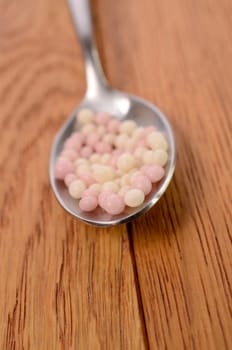 Steel spoon with sweet pearls of sugar