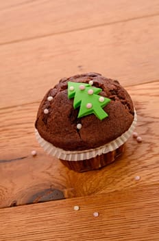 Muffin with a Christmas tree on an old wooden table