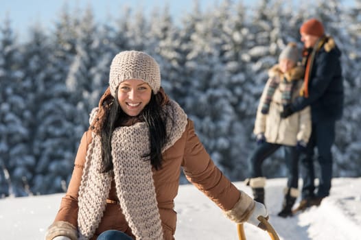 Winter young people friends enjoy snow on wooden sledge sunny