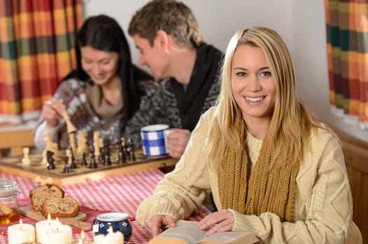 Young people spend winter holiday country cottage playing chess