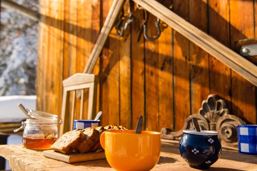 Breakfast on wooden table outside winter snow cottage
