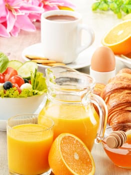 Breakfast with coffee, orange juice, croissant, egg, vegetables and fruits