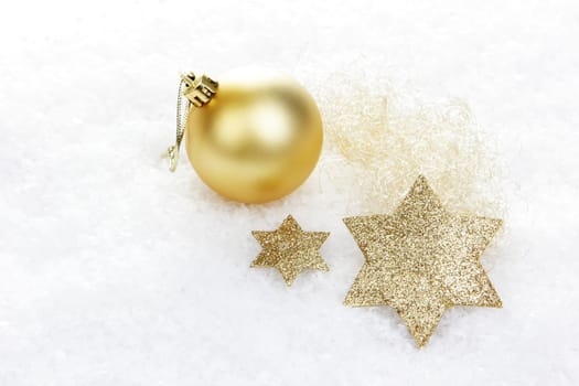 Christmas decorations,golden Christmas baubles and poinsettias on snow