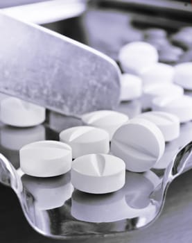 Close up of Counting tablets medical pills on stainless steel tray.(Health care and medical concept)