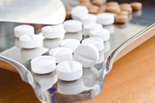 Close up of Counting tablets medical pills on stainless steel tray.(Health care and medical concept)