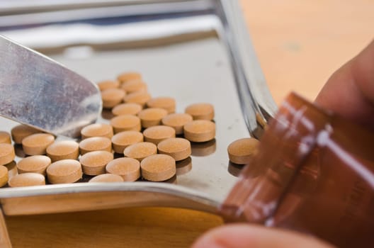Close up of Counting tablets medical pills on stainless steel tray.(Health care and medical concept)