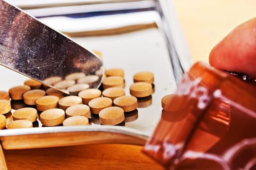 Close up of Counting tablets medical pills on stainless steel tray.(Health care and medical concept)