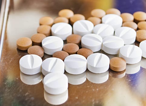 Close up of Counting tablets medical pills on stainless steel tray.(Health care and medical concept)