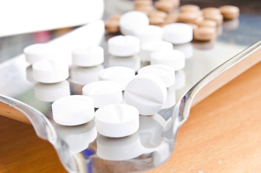 Close up of Counting tablets medical pills on stainless steel tray.(Health care and medical concept)