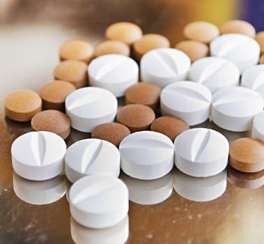 Close up of Counting tablets medical pills on stainless steel tray.(Health care and medical concept)