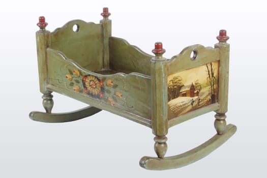 Hand-painted wooden doll's cradle against a white background