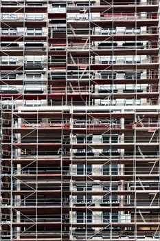 The photograph of a skyscraper covered with scaffolding.