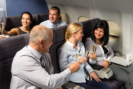 Airplane cabin businesspeople toasting with champagne flight travel passenger