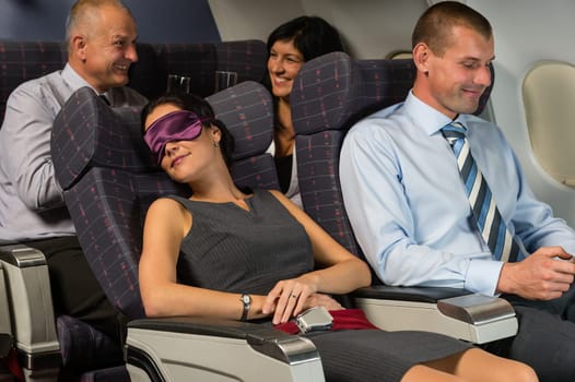 Business woman sleep during night flight airplane cabin passengers