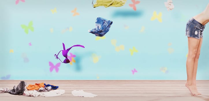 Young woman throwing clothes out of her closet