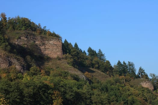 Low mountain landscape with trees and blue sky