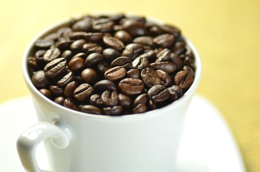 white coffee cup full of coffee beans