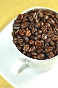 white coffee cup full of coffee beans