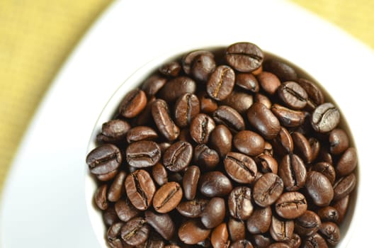 white coffee cup full of coffee beans