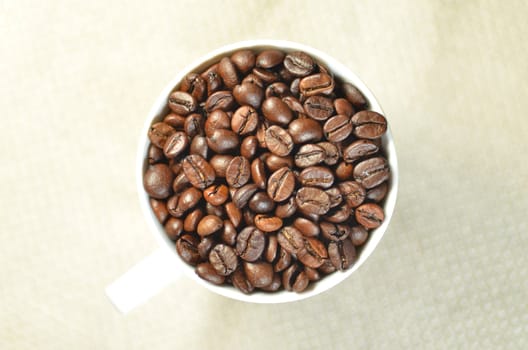 white coffee cup full of coffee beans