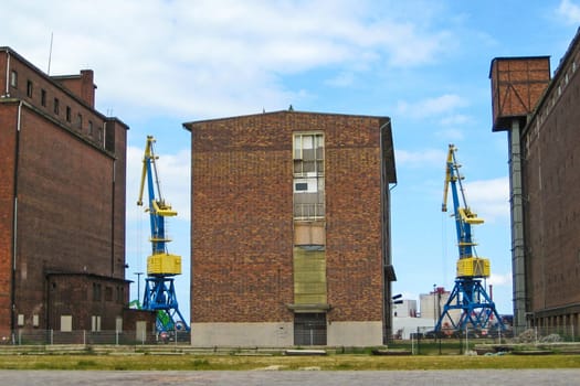 Colorful cranes between old brick buildings at the harbor of hansa town Wismar