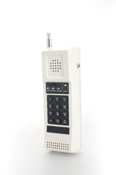 A white cordless telephone from the eigthes with black buttons and a telescopic antenna