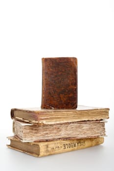 A book standing over three antique books (you can write on the cover of the standing one)