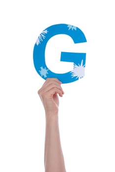 A Hand Holding the Blue and Snowy Letter G, Isolated