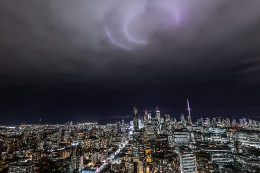 Full view of downtown Toronto at night with glamour spotlights pattern in the sky